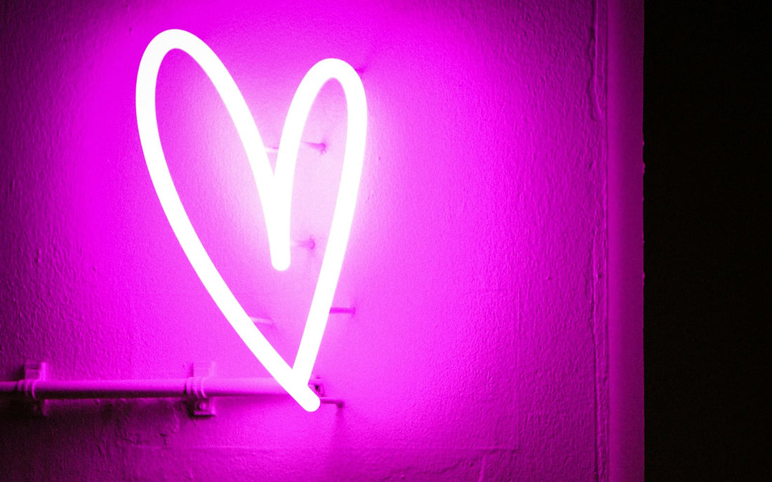 Glowing pink neon heart on a wall