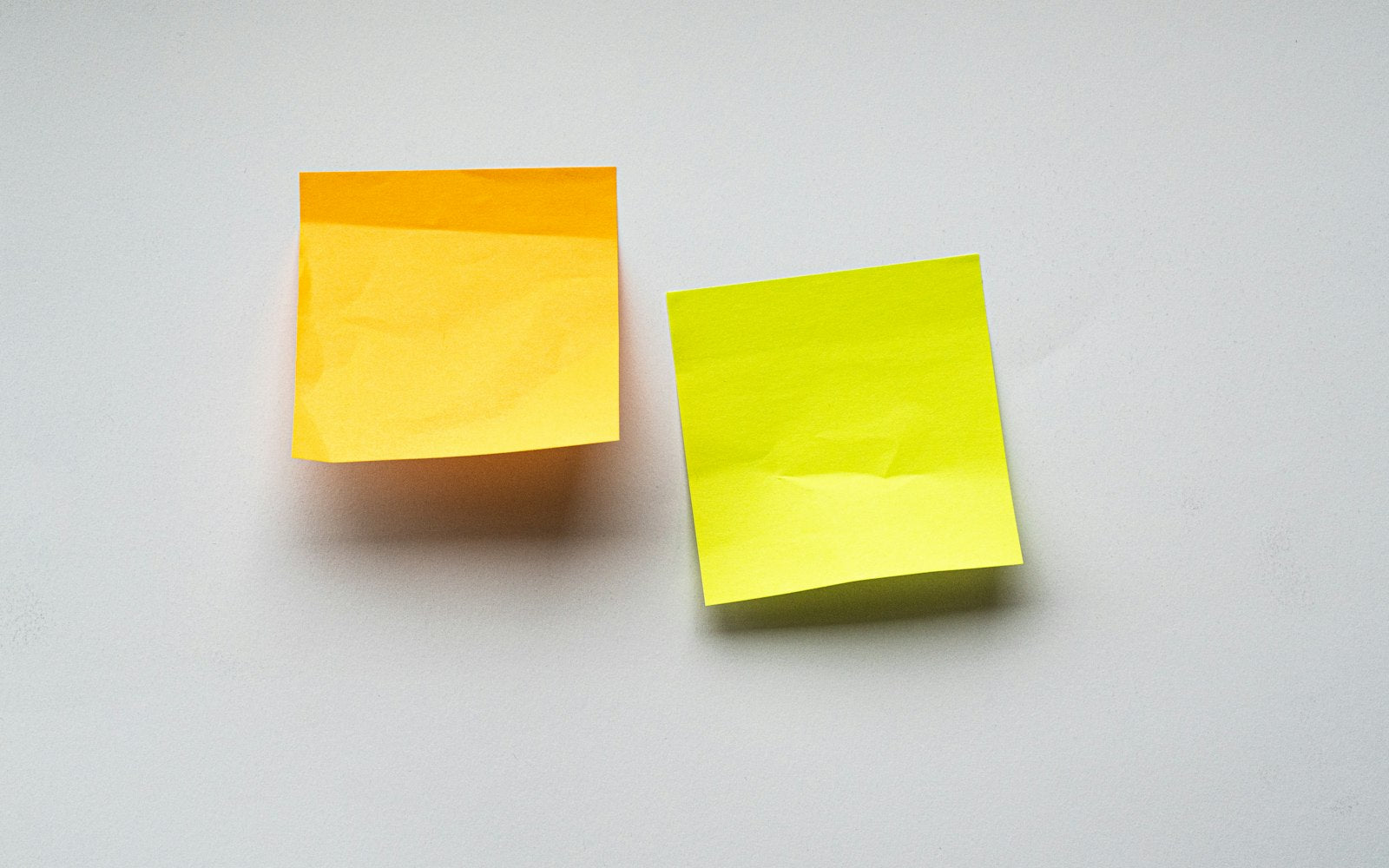Orange and yellow sticky notes on a white surface